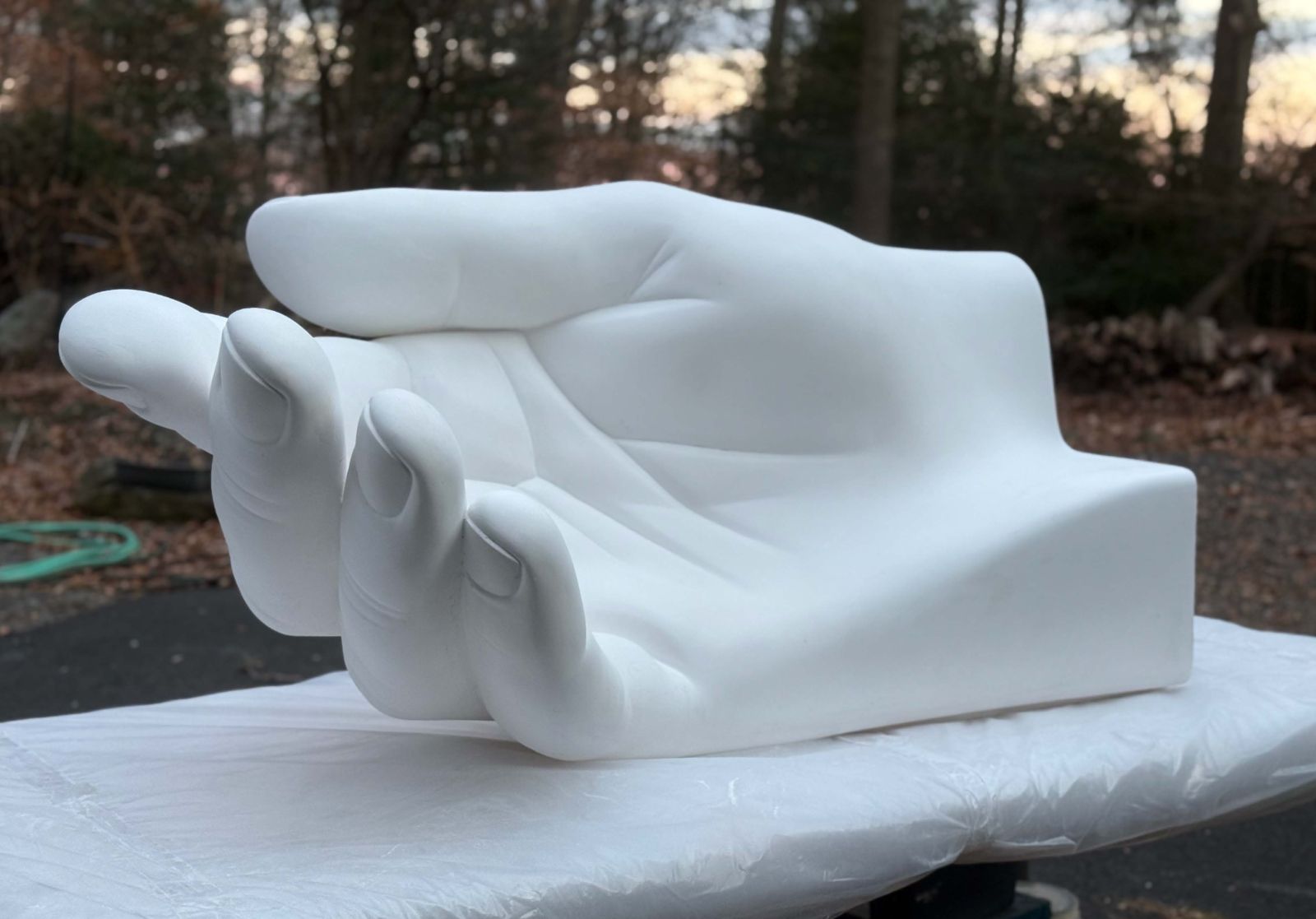 an image of a 2/3-scale plaster model of the open hand that will form the end of one of Peace Corps Park's three signature benches