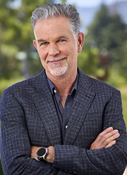 An image of Reed Hastings smiling, with his arms crossed